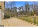 Spacious new wooden back deck with black railings overlooking the large yard and wooded area at 1312 Milstead Ne Ave, Conyers, GA 30012