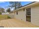 New wooden back deck with black railings, offering a cozy outdoor space, and entrance door at 1312 Milstead Ne Ave, Conyers, GA 30012