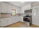 Well-lit kitchen with tile floors features white cabinets, stainless steel appliances at 1312 Milstead Ne Ave, Conyers, GA 30012