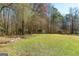 Spacious backyard with mature trees, lush lawn, and a storage shed at 260 Brookwood Ln, Fayetteville, GA 30215