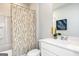 Well-lit bathroom featuring a white vanity, modern fixtures, and a shower-tub combo with patterned curtain at 337 Skylar Se Way, Atlanta, GA 30315