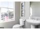 Modern half bathroom with a pedestal sink, toilet, and neutral color scheme at 337 Skylar Se Way, Atlanta, GA 30315