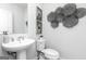 Stylish half bathroom with modern pedestal sink, sleek fixtures, and decorative wall art at 337 Skylar Se Way, Atlanta, GA 30315