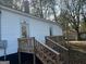 Exterior back of home featuring wooden stairs leading up to a small porch at 1 Maple St, Porterdale, GA 30014