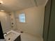 The bathroom has updated features like white tile floors, and a tub-shower combination at 1 Maple St, Porterdale, GA 30014