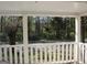 Covered front porch offers a serene view of the surrounding greenery at 1 Maple St, Porterdale, GA 30014
