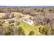 Aerial view shows a bright two-story home on a grassy lot surrounded by trees with a long driveway at 721 Wedowee St, Bowdon, GA 30108