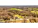 Aerial view shows a bright two-story home surrounded by grassy fields, trees, and other homes at 721 Wedowee St, Bowdon, GA 30108