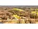 Aerial view shows a bright two-story home surrounded by grassy fields, trees, and other homes at 721 Wedowee St, Bowdon, GA 30108