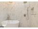 Close-up of a luxurious bathroom with a standalone tub, a luxe shower, and marble tiling at 721 Wedowee St, Bowdon, GA 30108