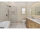 Bathroom featuring a standalone tub, a luxe shower, dual-sink vanity, and modern fixtures at 721 Wedowee St, Bowdon, GA 30108