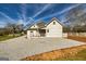 Newly renovated home with a new roof and gravel driveway, complemented by a pristine white fence at 721 Wedowee St, Bowdon, GA 30108