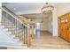 Bright foyer with hardwood floors, leading to a staircase with wrought iron spindles and a glimpse of the modern kitchen at 721 Wedowee St, Bowdon, GA 30108