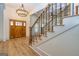 Elegant foyer featuring a staircase with iron spindles, a decorative chandelier, and warm wood flooring at 721 Wedowee St, Bowdon, GA 30108