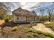 Charming single-story house featuring an arched garden trellis, a cozy front porch, and manicured landscaping at 721 Wedowee St, Bowdon, GA 30108