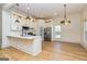 Modern kitchen with white cabinets, a central island, stainless steel appliances, and stylish pendant lighting at 721 Wedowee St, Bowdon, GA 30108