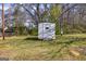 Exterior view of a utility shed on a lush green lawn, surrounded by trees and landscaping at 721 Wedowee St, Bowdon, GA 30108