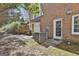 Rear of brick home with white door, and AC units in the backyard, with a gravel ground cover at 300 The Enclave, Peachtree City, GA 30269