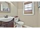 Stylish half bathroom featuring a vanity, toilet, and window at 300 The Enclave, Peachtree City, GA 30269