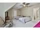 Neutral bedroom with a view of two twin beds and a wicker chair under a ceiling fan provides a comfortable, relaxing space at 300 The Enclave, Peachtree City, GA 30269
