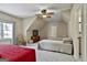 Bright bedroom features neutral walls, ceiling fan, and two twin beds, plus a red daybed, for versatile sleeping arrangements at 300 The Enclave, Peachtree City, GA 30269