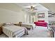 Neutral bedroom with twin beds and red daybed features unique ceiling architecture and a decorative ceiling fan at 300 The Enclave, Peachtree City, GA 30269