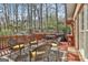 Relaxing deck area with wicker furniture and a grill, surrounded by mature trees at 300 The Enclave, Peachtree City, GA 30269