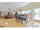 Open-concept dining area with wooden floors, a chandelier, and natural light from adjacent living space at 300 The Enclave, Peachtree City, GA 30269