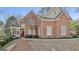 Charming red brick home featuring a covered porch and well-manicured landscaping at 300 The Enclave, Peachtree City, GA 30269