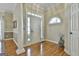 Bright foyer with hardwood floors, a decorative column, and a transom window at 300 The Enclave, Peachtree City, GA 30269