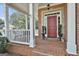 Welcoming front porch with classic red brick flooring and elegant white railings at 300 The Enclave, Peachtree City, GA 30269