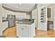 Kitchen with stainless steel fridge, granite countertops, white cabinets, and a central island at 300 The Enclave, Peachtree City, GA 30269