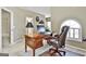 Bright office space features a large wood desk and chair near the arched window, perfect for a functional workspace at 300 The Enclave, Peachtree City, GA 30269