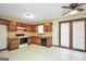 Traditional kitchen featuring wood cabinets, tile backsplash, and essential appliances, with a door to the outside at 40 Derby Country Dr, Ellenwood, GA 30294