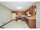 Traditional kitchen features classic cabinetry, white appliances, and durable tile flooring at 40 Derby Country Dr, Ellenwood, GA 30294