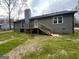 Rear view showing a wood deck with stairs and modern black metal railing at 127 Brookwood Estates Trl, Stockbridge, GA 30281