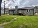 Backyard view with wood stairs leading to a rear deck and lush green lawn at 127 Brookwood Estates Trl, Stockbridge, GA 30281