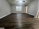 Sunlit bedroom showcasing dark wood flooring, gray walls, and a bright window overlooking nature at 127 Brookwood Estates Trl, Stockbridge, GA 30281