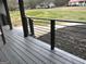 Covered porch with modern black metal railing overlooking landscaped front yard at 127 Brookwood Estates Trl, Stockbridge, GA 30281