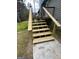 Close-up of outdoor wood stairs with metal railing, providing access to the backyard deck at 127 Brookwood Estates Trl, Stockbridge, GA 30281