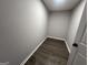 Compact walk-in closet featuring dark wood flooring and neutral gray walls. Great for storage at 127 Brookwood Estates Trl, Stockbridge, GA 30281