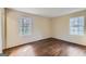 Sunlit bedroom featuring hardwood floors and two windows providing ample natural light at 6192 Holiday Blvd, Forest Park, GA 30297
