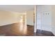 Spacious living room with hardwood floors, neutral walls, and a hallway coat rack at 6192 Holiday Blvd, Forest Park, GA 30297