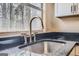 Close-up showcases a modern stainless steel sink with chrome fixtures and black countertop at 6192 Holiday Blvd, Forest Park, GA 30297