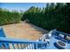 Lovely backyard with a blue deck, stone fire pit and trimmed evergreens for privacy at 106 Victoria Way, Carrollton, GA 30116