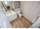 Bathroom features wood look flooring, white vanity, framed mirror, toilet, and shower/tub combo at 106 Victoria Way, Carrollton, GA 30116