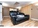 Finished basement living room with wood look flooring and a cozy black couch at 106 Victoria Way, Carrollton, GA 30116