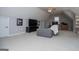 Open bonus room with gray sofa, television and built-in shelving at 106 Victoria Way, Carrollton, GA 30116