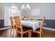 Formal dining room features natural lighting, hardwood floors, and six chairs around a set table at 106 Victoria Way, Carrollton, GA 30116
