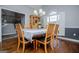 Bright dining room with stylish chandelier, window shutters, wood floors, and views to the staircase at 106 Victoria Way, Carrollton, GA 30116